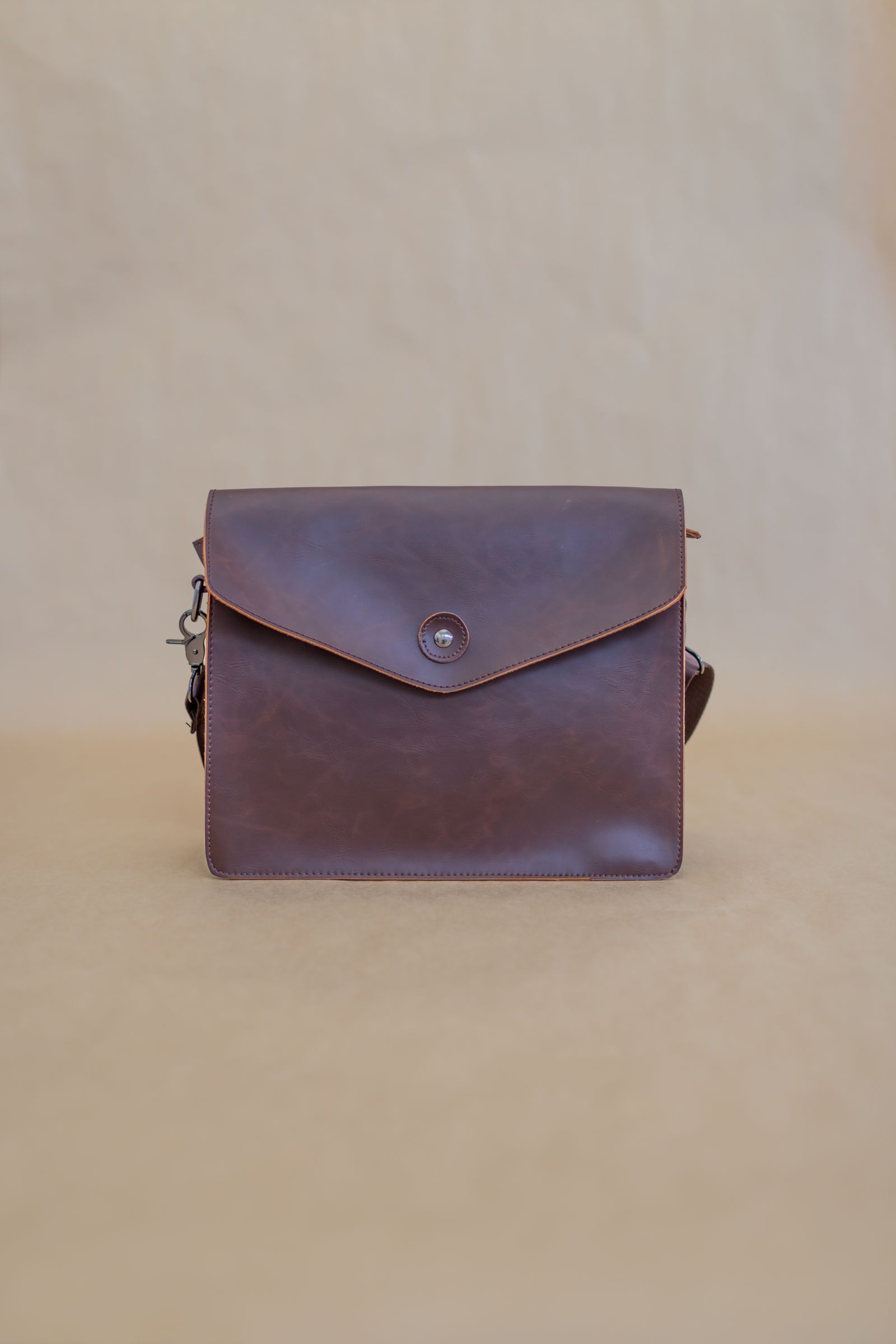 Brown leather handbag on neutral background