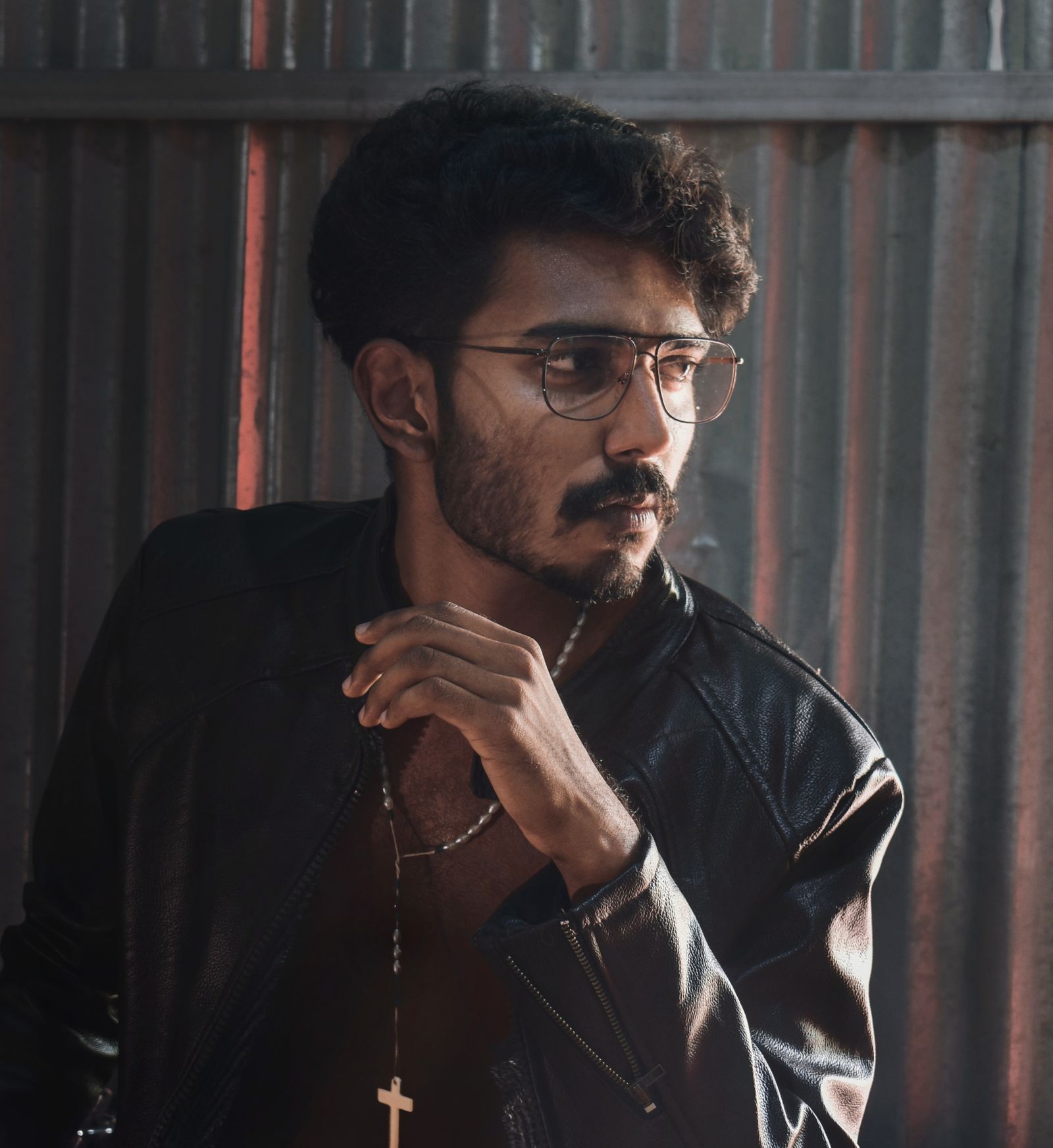 Man in black leather jacket wearing eyeglasses